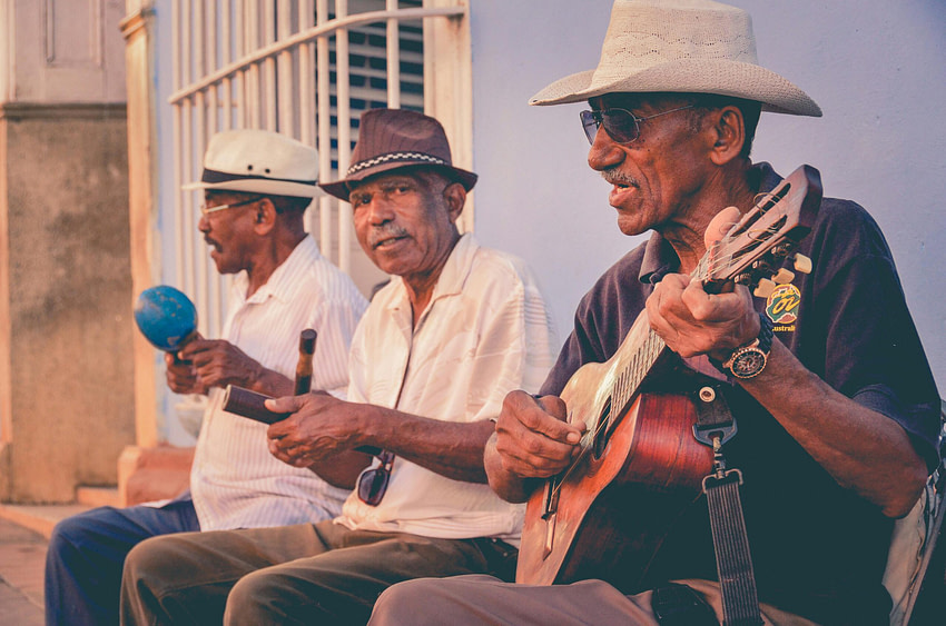 Homens idosos tocando música juntos, símbolo de coordenação, movimento e vida social.